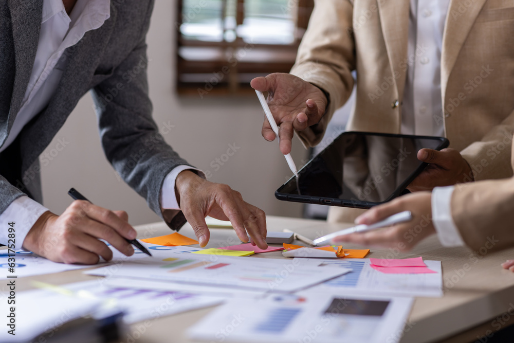 Group of confident business people point to graphs and charts to analyze market data, balance sheet, account, net profit to plan new sales strategies to increase production capacity. Group of confident business people point to graphs and charts to analyze market data, balance sheet, account, net profit to plan new sales strategies to increase production capacity.
