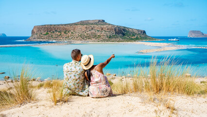 Crete Greece, Balos lagoon Crete island, Greece. Tourists relax at the crystal clear ocean of Balos Beach. a couple of men and a woman visit the beach during a vacation in Greece on a sunny day
