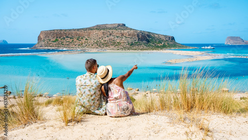 Crete Greece, Balos lagoon Crete island, Greece. Tourists relax at the crystal clear ocean of Balos Beach. a couple of men and a woman visit the beach during a vacation in Greece on a sunny day