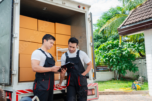 Unloading boxes and furniture from a pickup truck to a new house with service cargo two men movers worker in uniform lifting boxes. concept of Home moving and delivery.