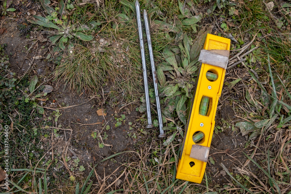 Fototapeta premium two large steel nails together with a hand level, archeological works