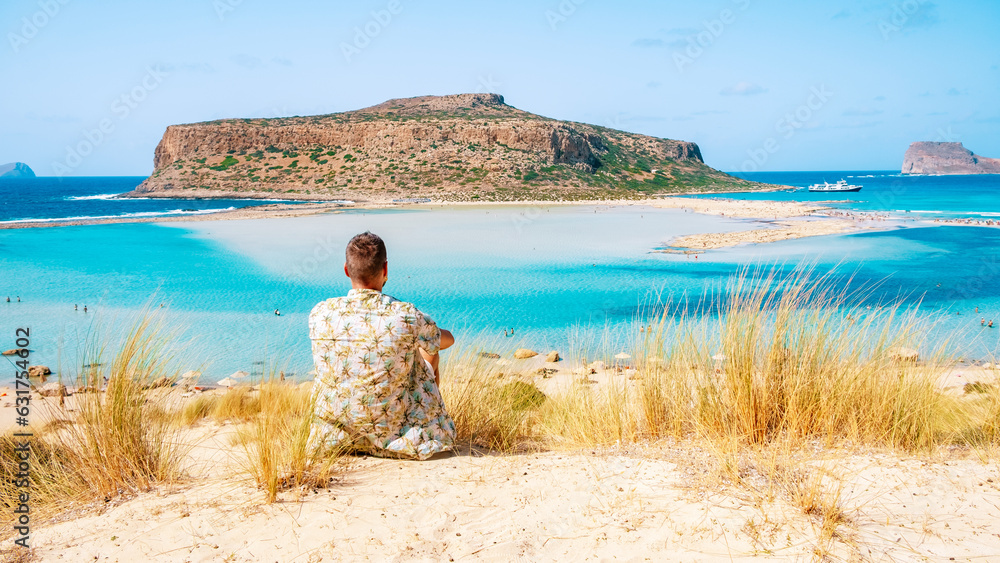 Crete Greece, Balos lagoon on Crete island, Greece. Tourists relax at the crystal clear ocean of Balos Beach. Greece, a young men visit the beach during a vacation in Greece