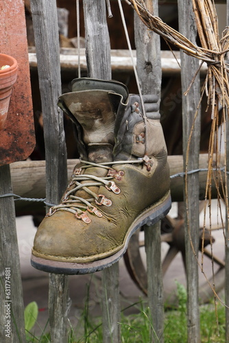 old hiking boots hanging on a fence