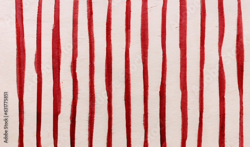 immagine primo piano di spesse righe verticali irregolari in inchiostro rosso su carta ruvida, vista dall'alto
