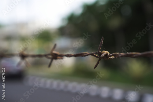 Barbed wire Fence with pointed iron at the top for protection so that thieves, crime, or wild animals do not enter the area. Concept for defensive, prevention, safety, mitigation. photo
