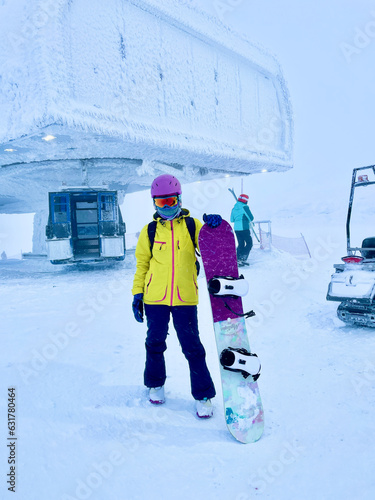 bright girl with snowboard in mountains Bigwood resort Kirovsk
