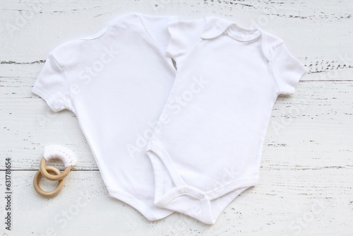 Baby bodysuit front and back template on white wooden background.