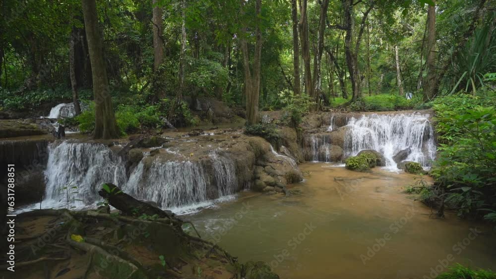 waterfall stream on nature clear slow motion water and green jungle to tree roots in natural forest or rainforest at Kroeng Krawia waterfall in Thailand on rainy season for wild landscape background waterfall stream on nature clear slow motion water and green jungle to tree roots in natural forest or rainforest at Kroeng Krawia waterfall in Thailand on rainy season for wild landscape background