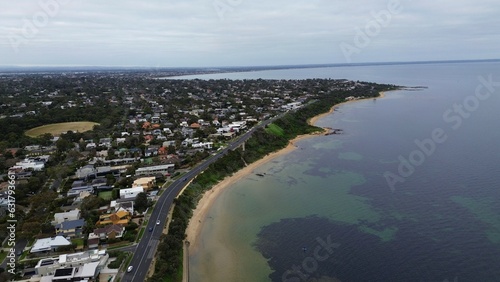 aerial view of the city and beach next to Australian bay area with patches of corals underwater