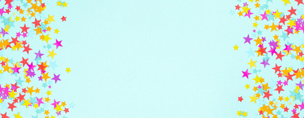Festive background. Flat lay, top view of colorful stars, stars on pastel blue background. Decoration party, birthday, anniversary, Christmas, New Year celebration concept. banner