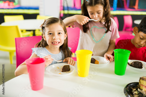 Adorable girls smiling at a friends birthday party in the playroom