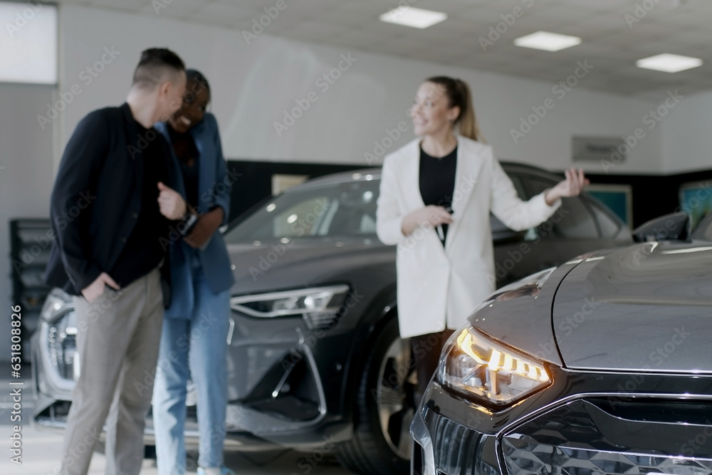 Car showroom. The manager shows the car to buyers in the showroom. copy space Car showroom. The manager shows the car to buyers in the showroom. copy space