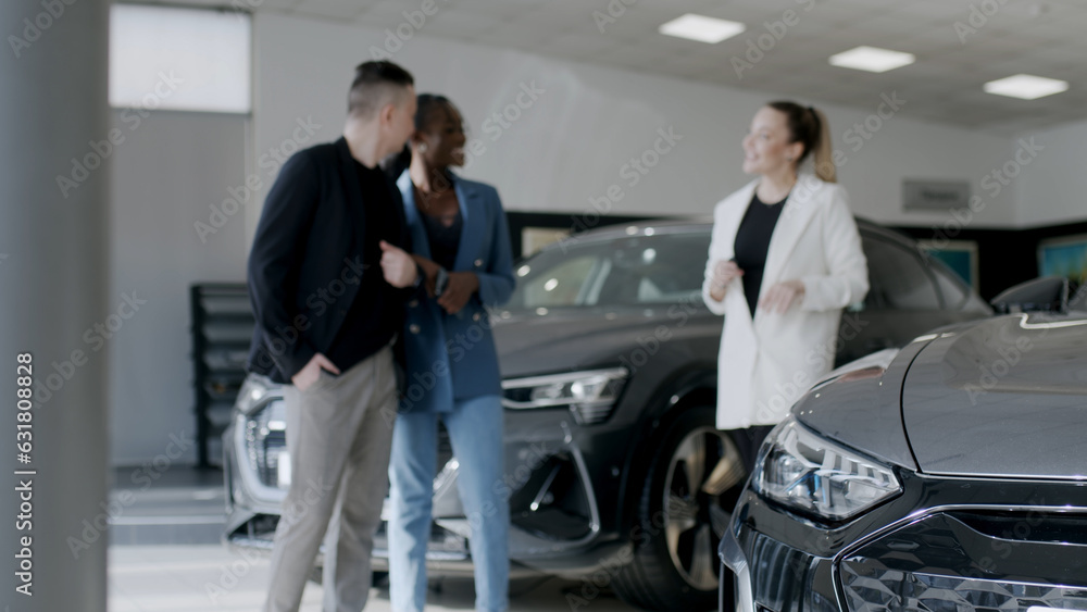 Car showroom. The manager shows the car to buyers in the showroom. copy space Car showroom. The manager shows the car to buyers in the showroom. copy space