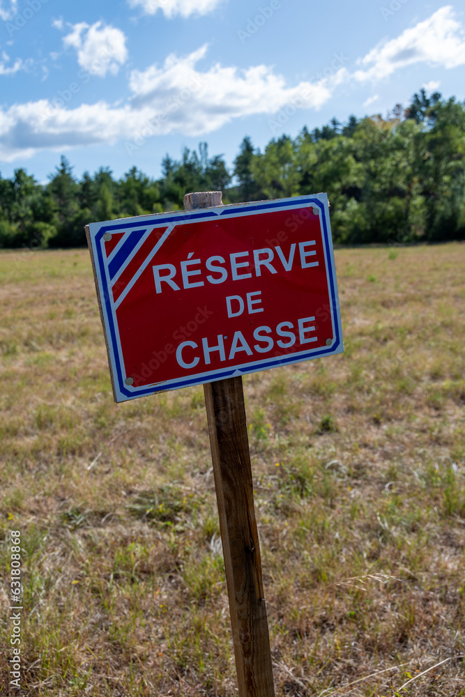 Panneau d'information écrit en Français signalant la présence d'une réserve de chasse, zone dans laquelle il est interdit de chasser afin de permettre le renouvellement des populations de gibier Panneau d'information écrit en Français signalant la présence d'une réserve de chasse, zone dans laquelle il est interdit de chasser afin de permettre le renouvellement des populations de gibier