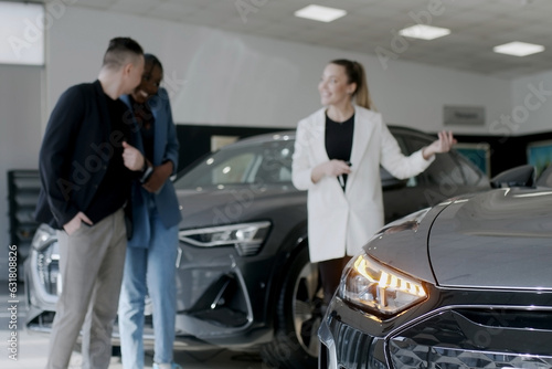 Car showroom. The manager shows the car to buyers in the showroom. copy space