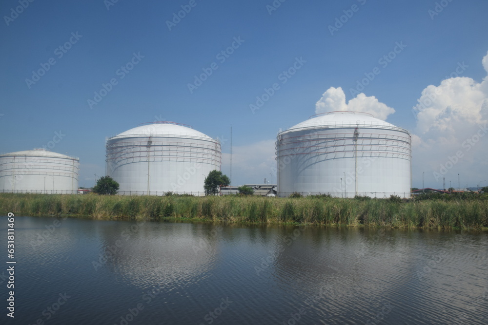 Fototapeta premium Giant tank for oil storage, which is on the edge of the river