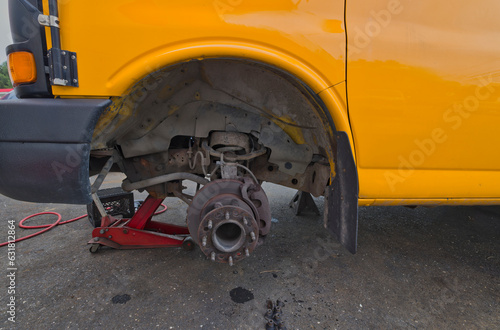 Brakes being repaired on yellow school bus.  © Loren Biser