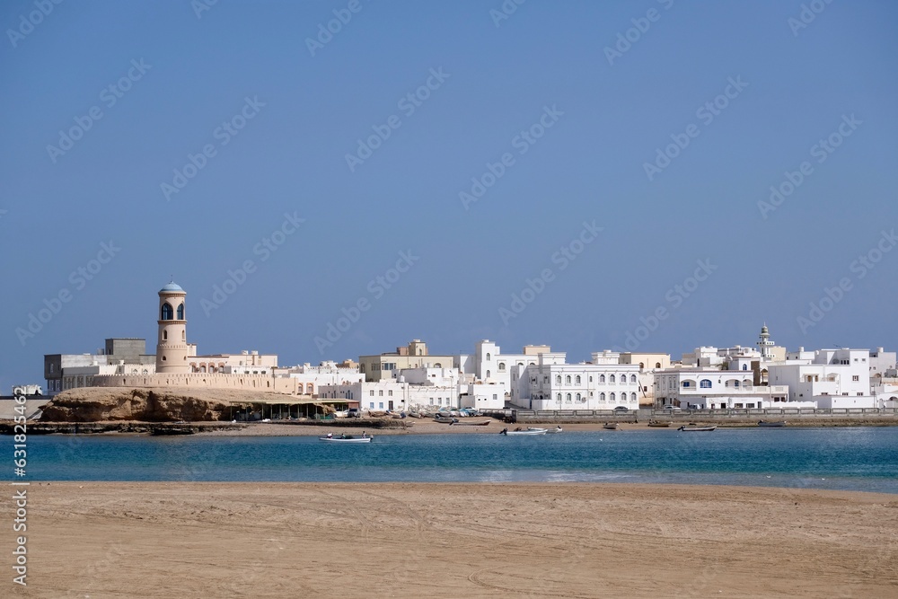 The lighthouse and the whitewashed houses of old town Sur in Sultanate of Oman