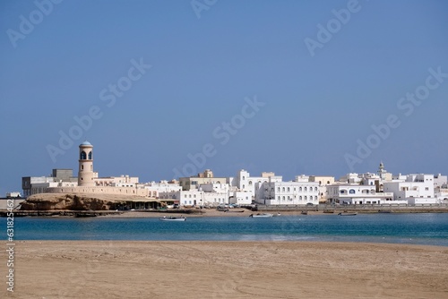 The lighthouse and the whitewashed houses of old town Sur in Sultanate of Oman