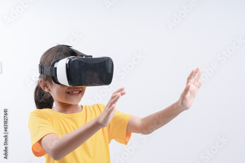 Amazed teenage girl using virtual reality glasses, pulls hand forward. Smiling stylish teen girl wear vr headset, playing video game, isolated over studio white background. Future technology concept