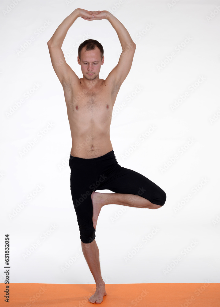 Man doing yoga in photo studio on isolated background.	
