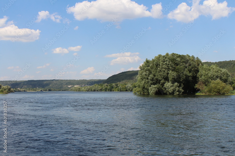 A body of water with trees and hills in the background