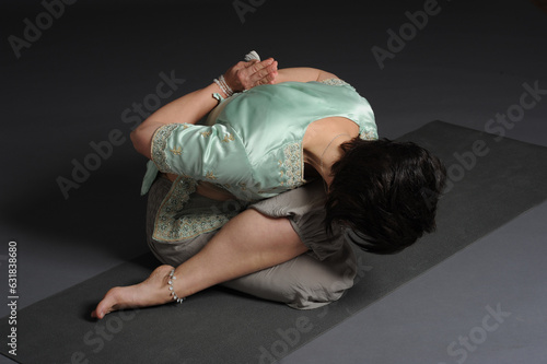 Woman doing yoga in photo studio on isolated background. 