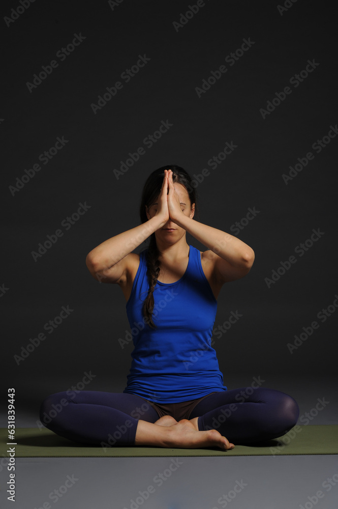 Woman doing yoga in photo studio on isolated grey background. Woman doing yoga in photo studio on isolated grey background.