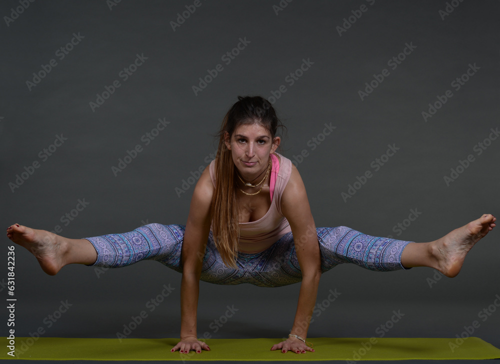 Woman doing yoga in photo studio on isolated background.	
