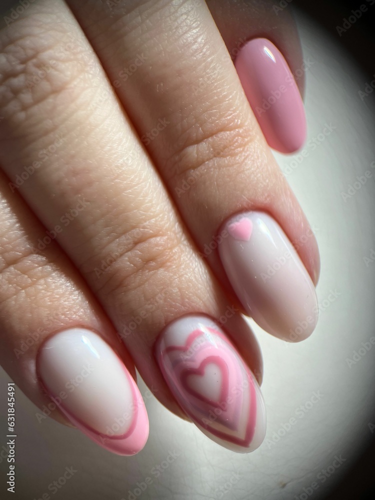 Vertical closeup shot of fingers with a trendy pastel-colored gel nail polish with hearts. Vertical closeup shot of fingers with a trendy pastel-colored gel nail polish with hearts.