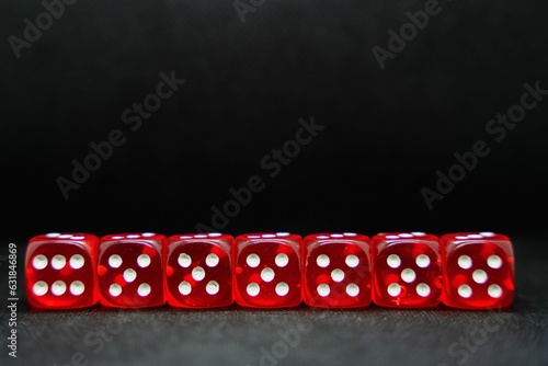 Close up of a line of red dice isolated on a black background photo