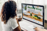 Woman ues laptop with healthy blog online social media content, food blogging, working online, content creator, health, blogger, technology, weblog, wellness, woman reading healthy blog online at home