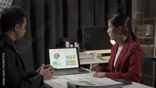 Young Asian businessman, man and woman working in office with laptop computers and financial documents.