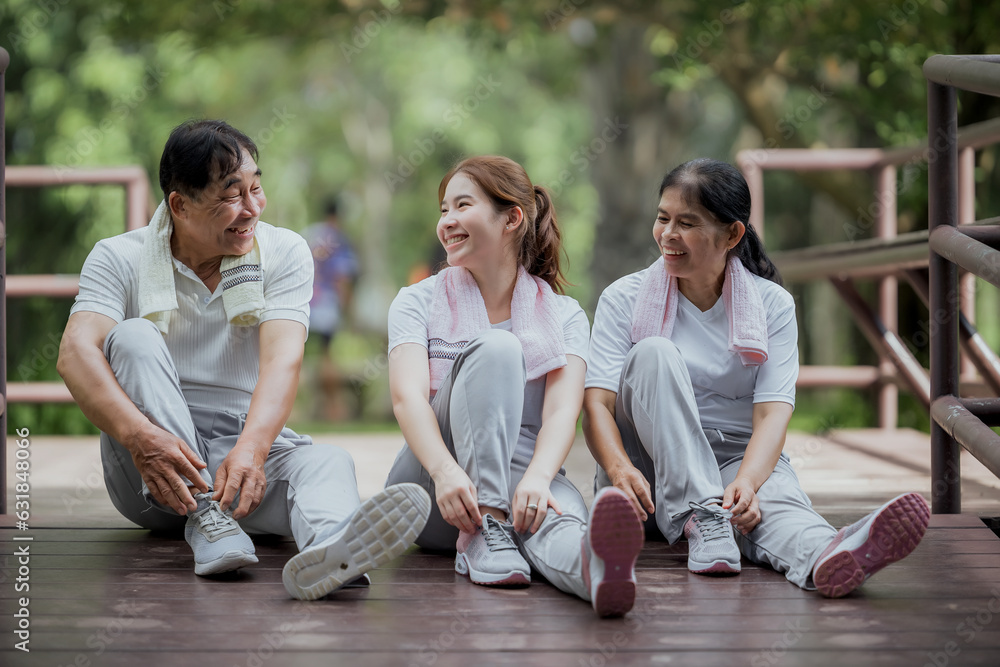 Fototapeta premium Beautiful Asian woman taking her father and mother to exercise in the park happily, with a smile. Young woman invites parents to exercise, warm family, good health. concept health care life insurance.