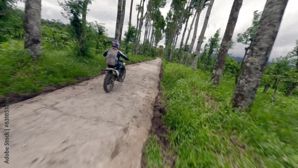 Enduro motorcycle biker speed riding race on path way trying standing wheelie wood forest tree valley aerial view. FPV drone shot motorbike rider backpack driving road extreme sport motocross travel Enduro motorcycle biker speed riding race on path way trying standing wheelie wood forest tree valley aerial view. FPV drone shot motorbike rider backpack driving road extreme sport motocross travel