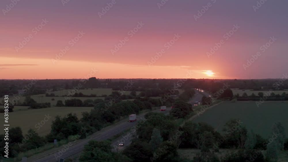 Drone view of cars driving on roads between rural fields during sunset Drone view of cars driving on roads between rural fields during sunset