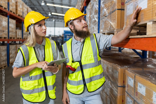 Male and Female professional worker wearing safety uniform using tablet inspect goods on shelves in warehouse. supervisor worker checklist stock inspecting product in storage for logistic.