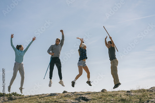 Two gorgeous girls and two handsome men jumping on top of the mountain