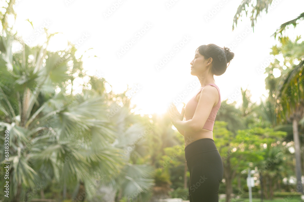 concept of wellness and well being fit 30s young Asian woman in pink sportswear engages yoga and stretches muscles. Embrace healthy outdoor lifestyle with fitness yoga girl in public park at sunset. concept of wellness and well being fit 30s young Asian woman in pink sportswear engages yoga and stretches muscles. Embrace healthy outdoor lifestyle with fitness yoga girl in public park at sunset.