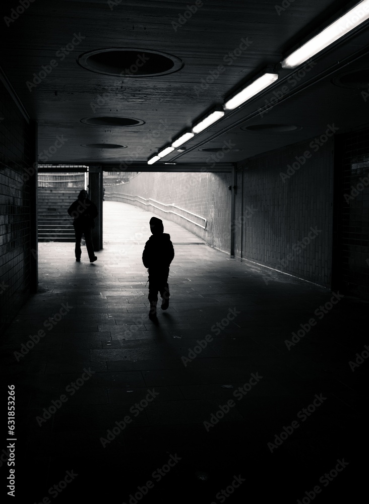 People walking through a dark underground tunnel