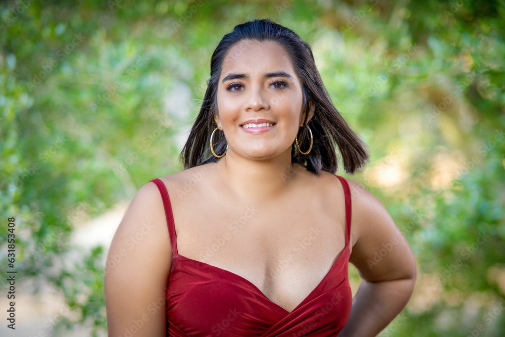 Beautiful Hispanic model posing in a red dress outdoors during sunrise Beautiful Hispanic model posing in a red dress outdoors during sunrise