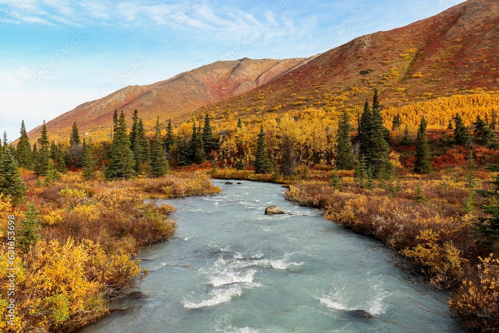 Landscape of a river surrounded by mountains and yellowing trees Landscape of a river surrounded by mountains and yellowing trees