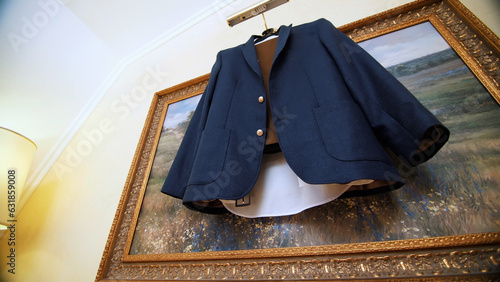 in the room, on the background of the picture, a dark blue men's jacket hangs on a hanger. close-up photo
