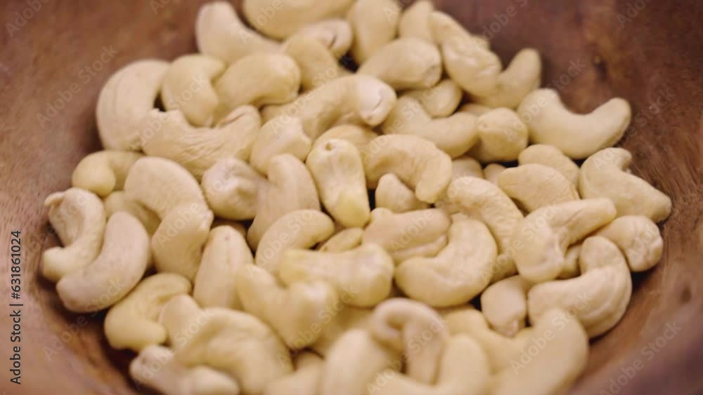 Nutritious raw cashew nuts in a wooden bowl. Healthy dietary food ingredient closeup Nutritious raw cashew nuts in a wooden bowl. Healthy dietary food ingredient closeup