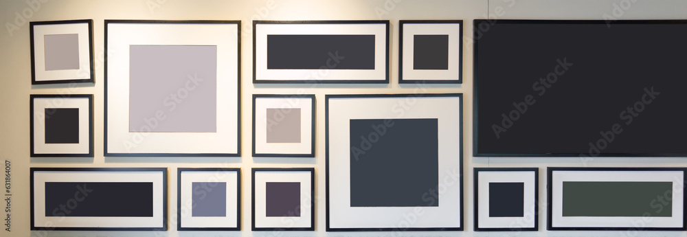 A Wall of Memories: Black, White, and Gray Picture Frames on a White Wall A Wall of Memories: Black, White, and Gray Picture Frames on a White Wall