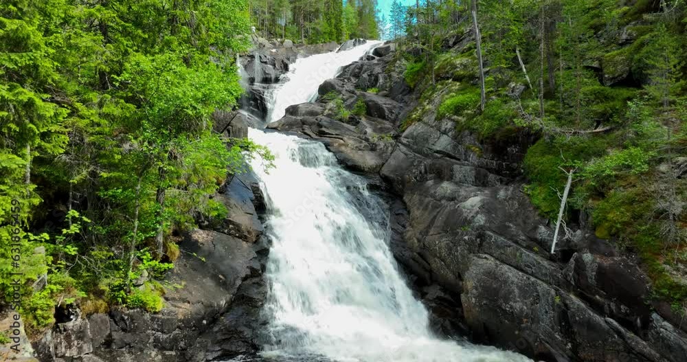 Aerial video of a waterfall surrounded by bright green trees in the forest Aerial video of a waterfall surrounded by bright green trees in the forest