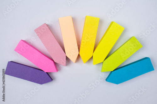 Colorful sticky notes arranged on white background. Arrow shape sticky notes pointing to same point.