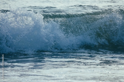 Waves rolling in the ocean with small waves on it © Sunanda/Wirestock Creators