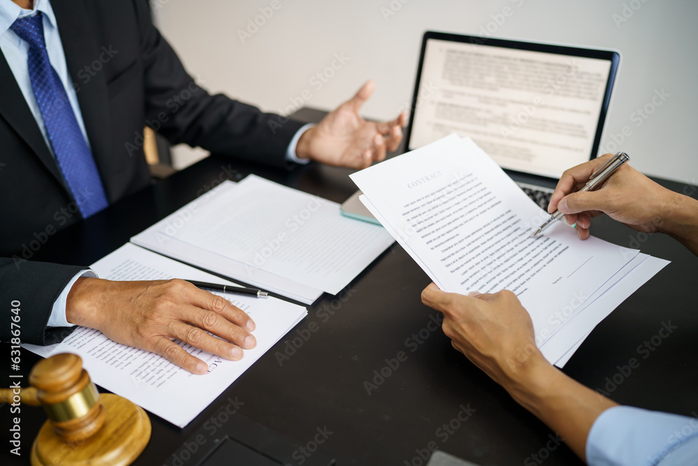 Legal counsel presents to the client a signed contract with gavel and legal law. justice and lawyer concept Legal counsel presents to the client a signed contract with gavel and legal law. justice and lawyer concept