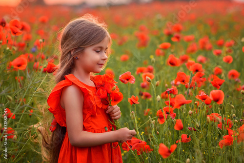 beautiful little girl in a field with poppy flowers in a red dress at sunset in summer. on the head a wreath of poppies. Holidays in summer. rest at the grandmother's in the village